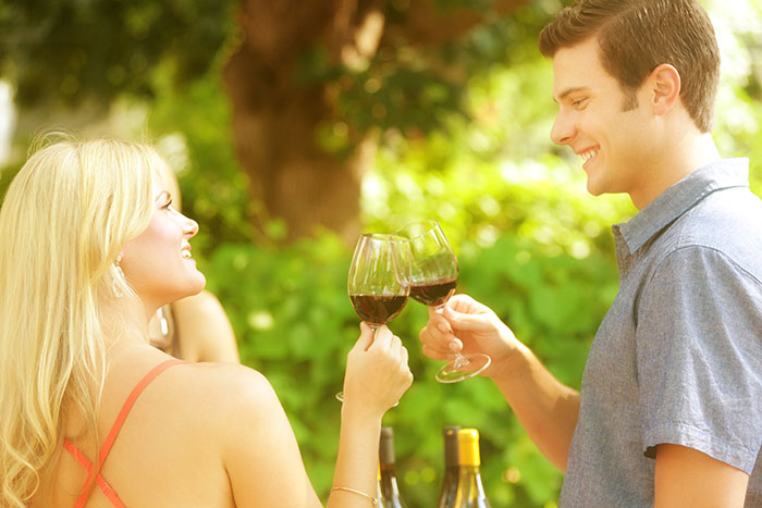 couple toasting with glasses of red wine outdoors