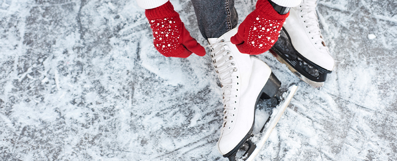 lacing up ice skates in red mittens