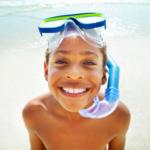 kid with snorkel gear on at the beach