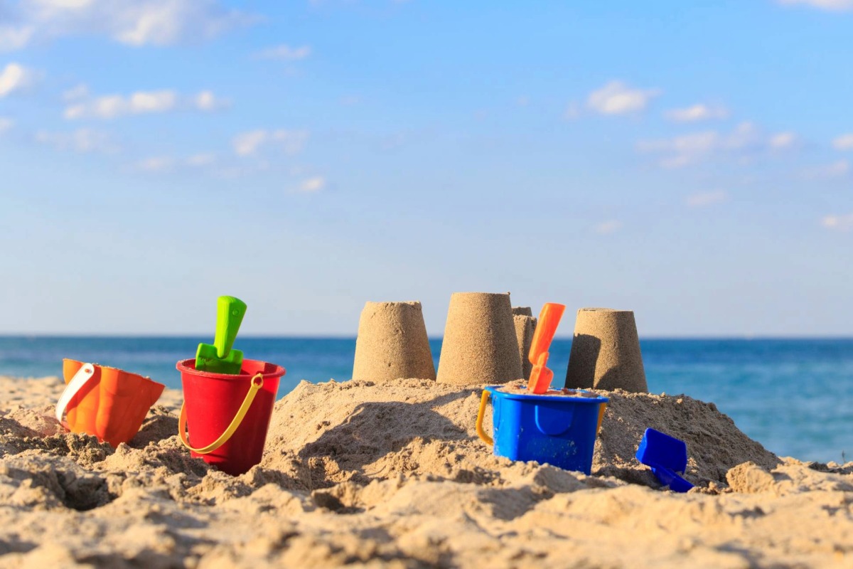 Sand castle on the beach with toys
